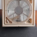Ventilateur de plafond en plastique beige.