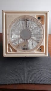 Ventilateur de plafond en plastique beige.