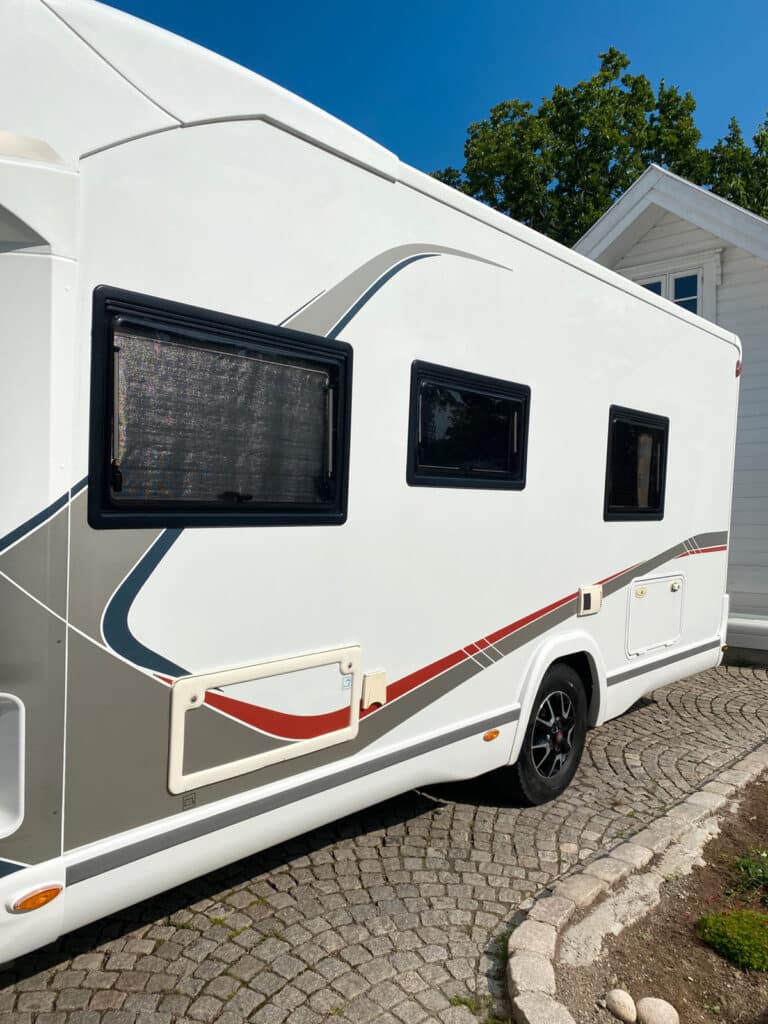 Camping-car stationné sur allée pavée.