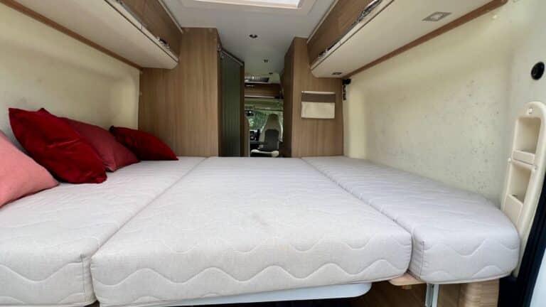 Intérieur d'un van aménagé avec lit convertible.
