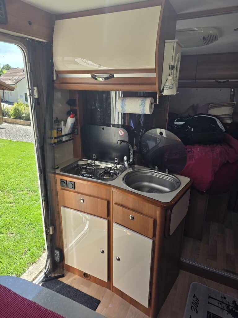 Cuisine de camping-car avec évier et plaque de cuisson.