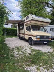 Camping-car ancien stationné sur un terrain herbeux