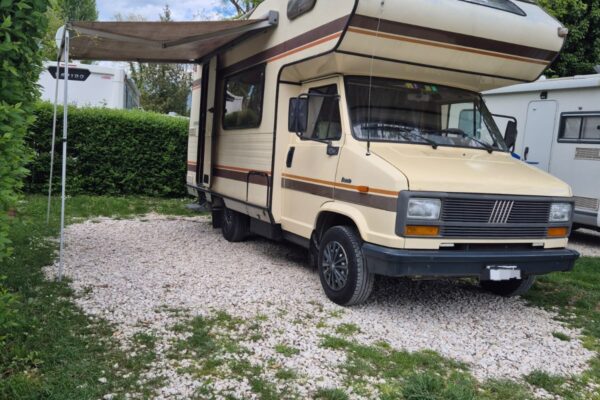 Camping-car ancien stationné sur un terrain herbeux