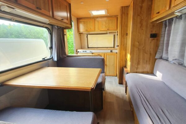 Aus Holz eingerichteter Innenraum eines Wohnwagens.