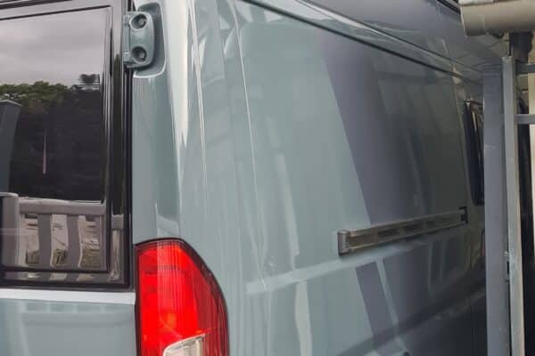 1TP290Graue Lieferwagen mit Vordach unter Schutzdach.