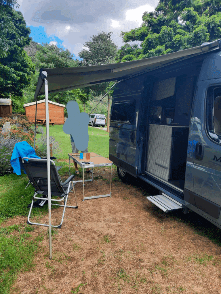Camping-car stationné avec auvent déployé.