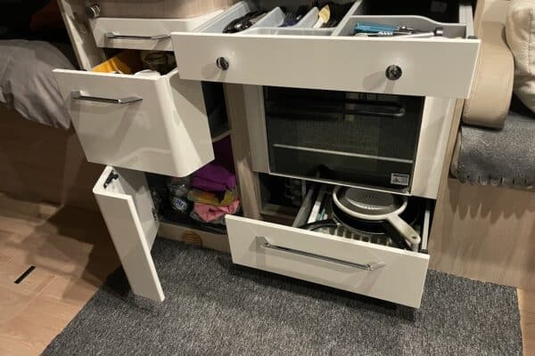 Kompaktküche mit offenen Schubladen in einem Wohnmobil.