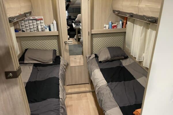 Wohnwageninnenraum: Einzelbetten und Stauräume.