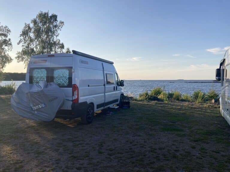 Camping-car en bord de mer au coucher de soleil.