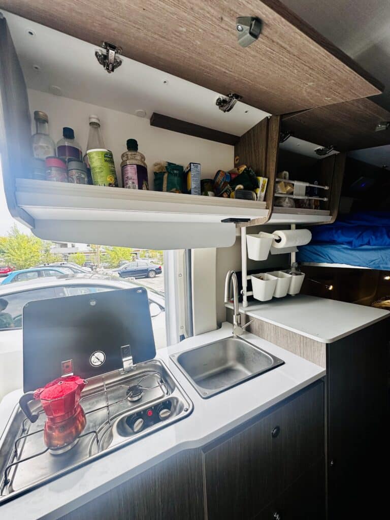 Cuisine de camping-car avec évier et plaques de cuisson.