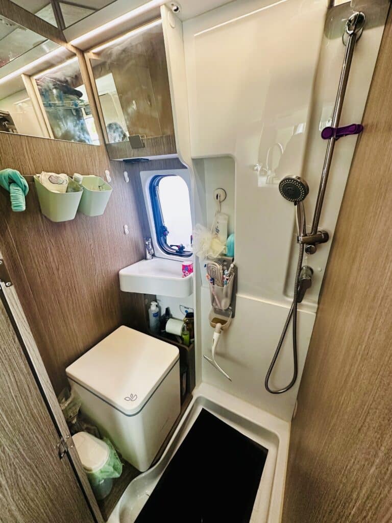 Salle de bain compacte avec douche et toilettes.