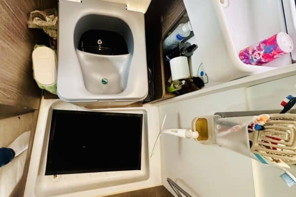 Kompaktes Badezimmer mit offenem Waschbecken und Schrank.