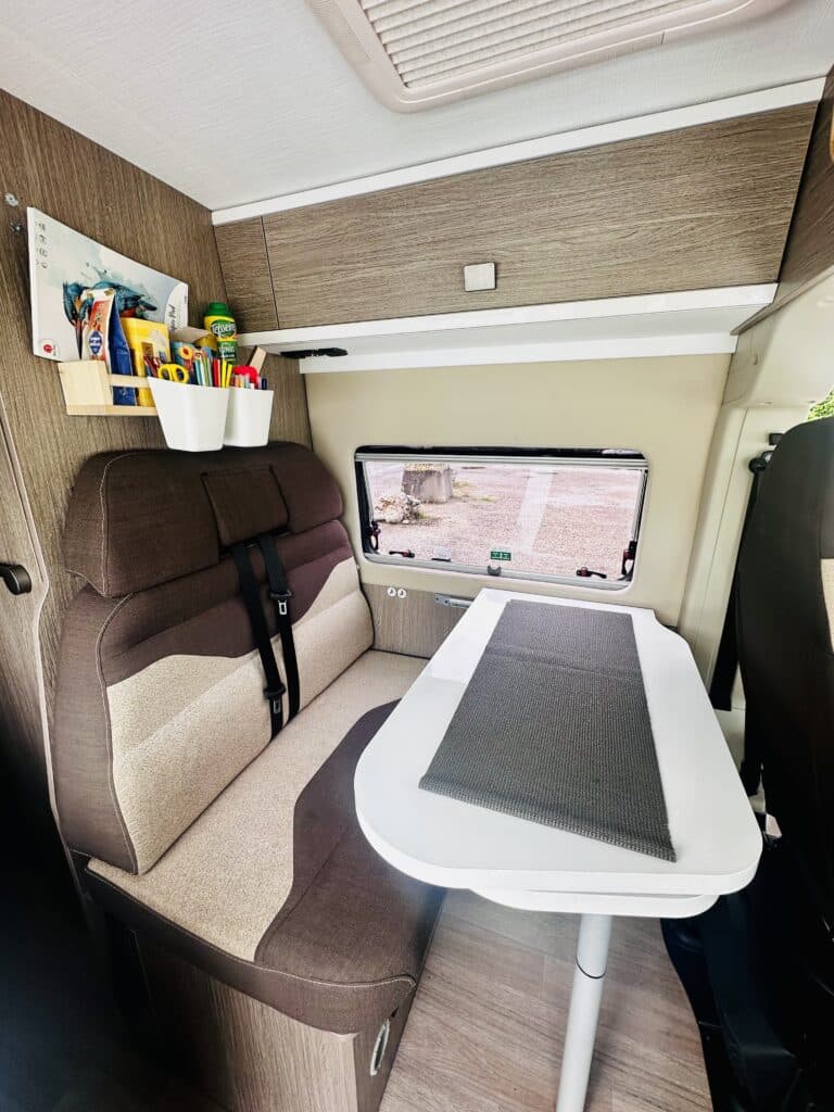 Intérieur de camping-car avec table et sièges.