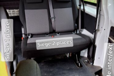 Innenraum eines Campervans mit Sitzen und Bett.