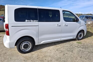 1TP272Weißer Lieferwagen, der auf einem Weg geparkt ist.