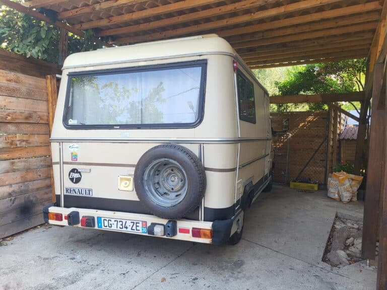 Caravane vintage Renault stationnée sous un abri.