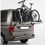 Vélo monté à l'arrière d'un van brun.