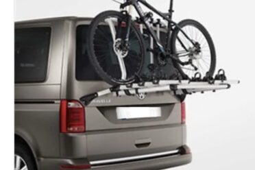 Vélo monté à l'arrière d'un van brun.