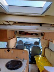 Intérieur d'un camping-car avec kitchenette et sièges.