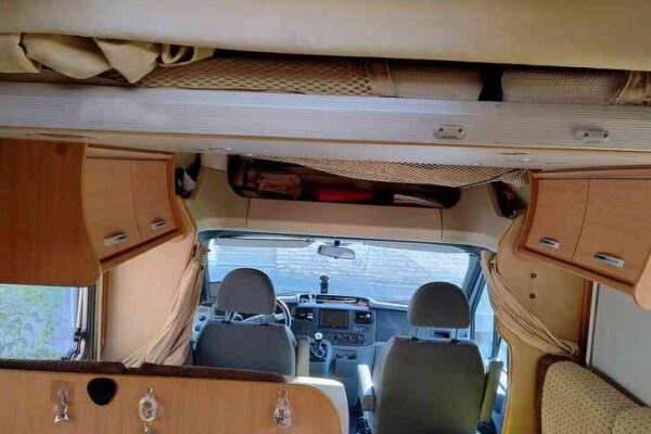 Intérieur d'un camping-car avec kitchenette et sièges.