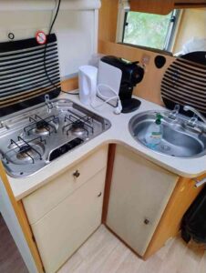 Cuisine compacte de camping-car avec évier et plaques.
