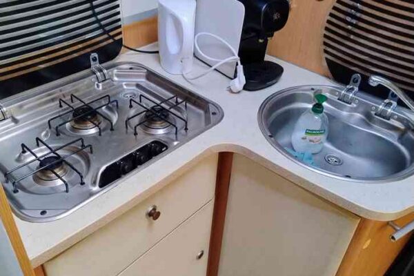 Cuisine compacte de camping-car avec évier et plaques.