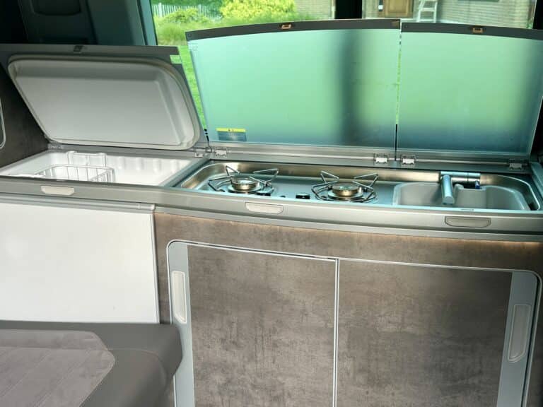 Cuisine de camping-car moderne avec évier et réchaud.