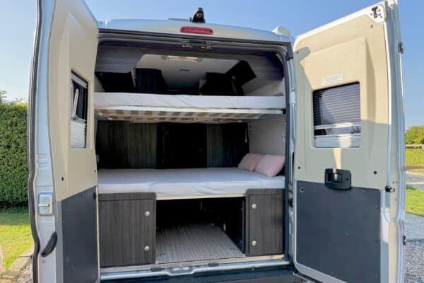 Intérieur de van aménagé avec lits superposés.