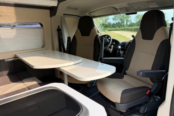 Intérieur de camping-car avec sièges pivotants et table.
