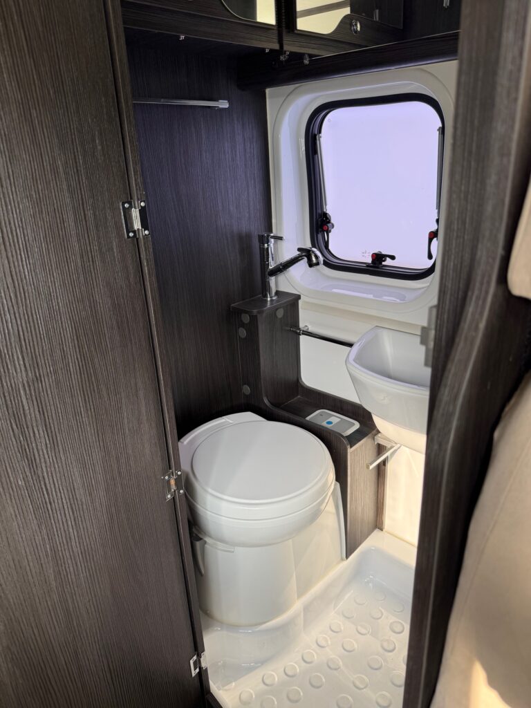 Salle de bain compacte avec toilettes et fenêtre.
