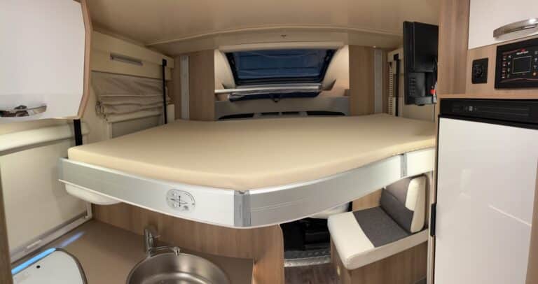 Intérieur confortable de camping-car avec lit repliable.
