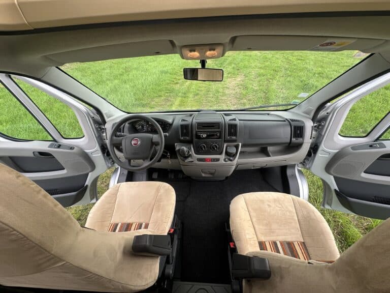 Intérieur d'un camping-car avec vue sur le tableau de bord.