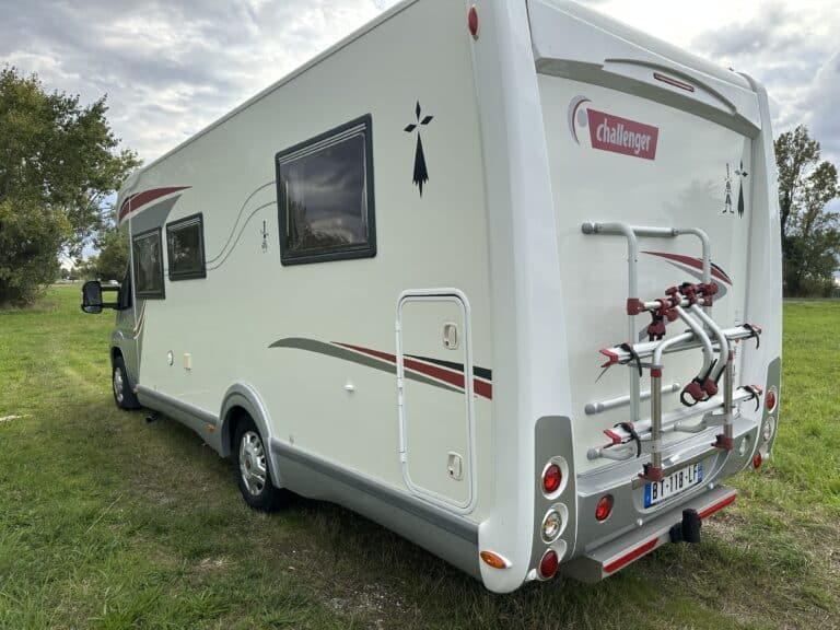 Camping-car blanc sur herbe verte.