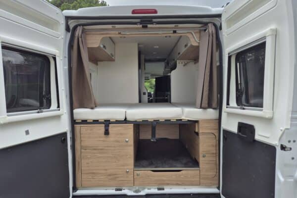 Innenausstattung von Campervan mit Bett und Stauraum.