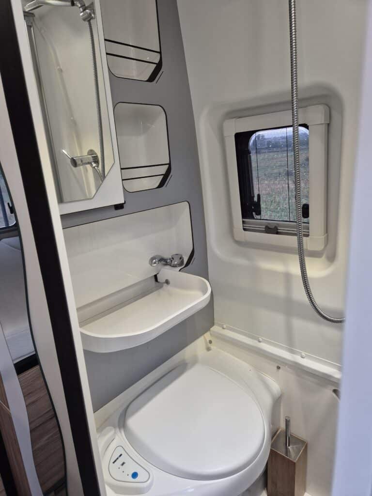Salle de bain compacte avec douche et toilettes.
