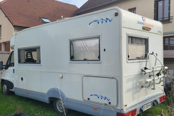 Camping-car garé devant une maison.