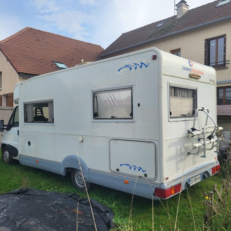 Camping-car garé devant une maison.