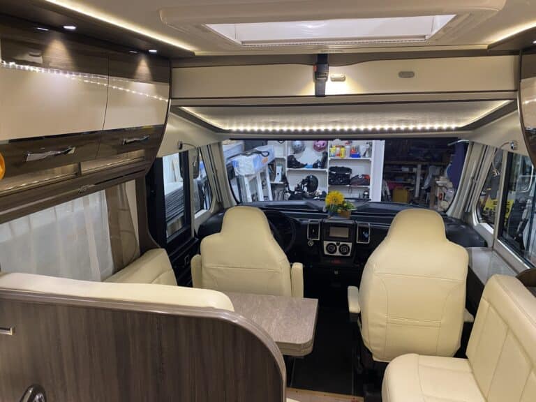 Intérieur de camping-car avec sièges et rangements.