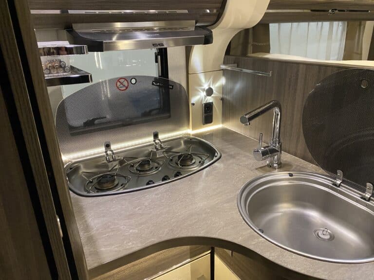 Cuisine moderne d'une caravane avec plaque et évier.