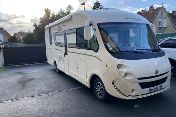 Camping-car stationné devant une maison.