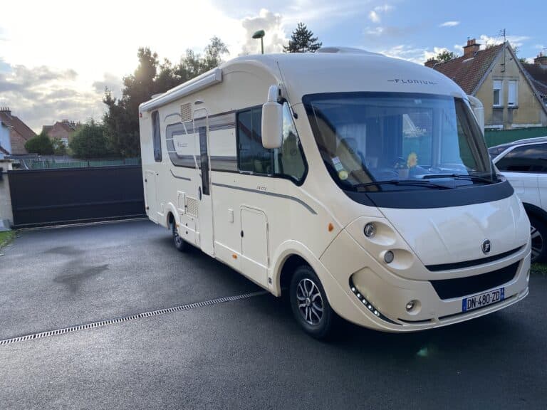 Camping-car stationné devant une maison.