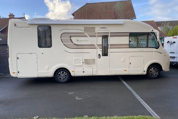 Camping-car stationné sur un parking résidentiel.