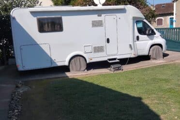 Camping-car stationné dans une allée pavée.