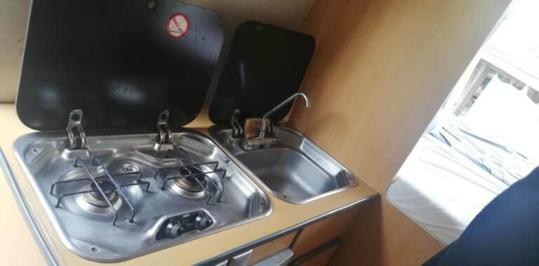 Cuisinière et évier dans une cuisine compacte caravane.