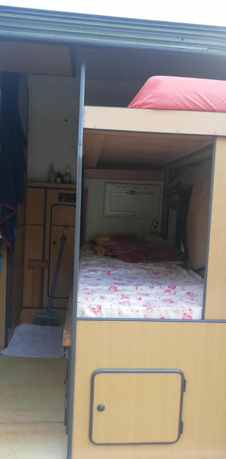 Lit dans un intérieur de caravane aménagée.