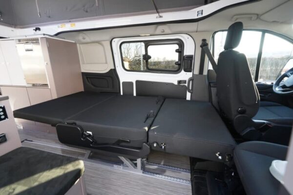 Intérieur d'un van aménagé avec lit déplié