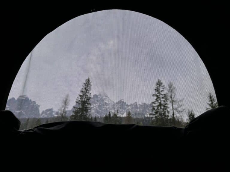 Vue des montagnes enneigées depuis une tente.