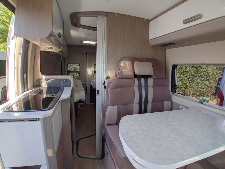 Intérieur d'un camping-car moderne avec salon et cuisine.
