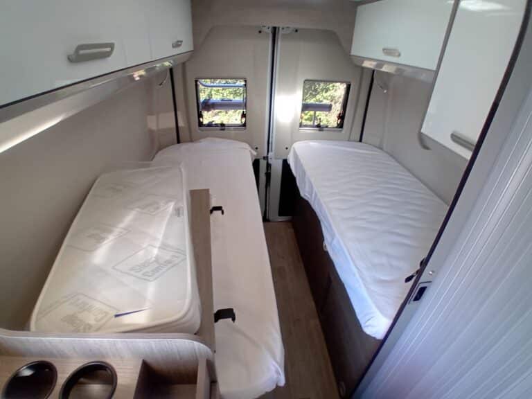 Intérieur de camping-car avec deux lits simples.