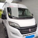 Camping-car blanc garé sous un abri.